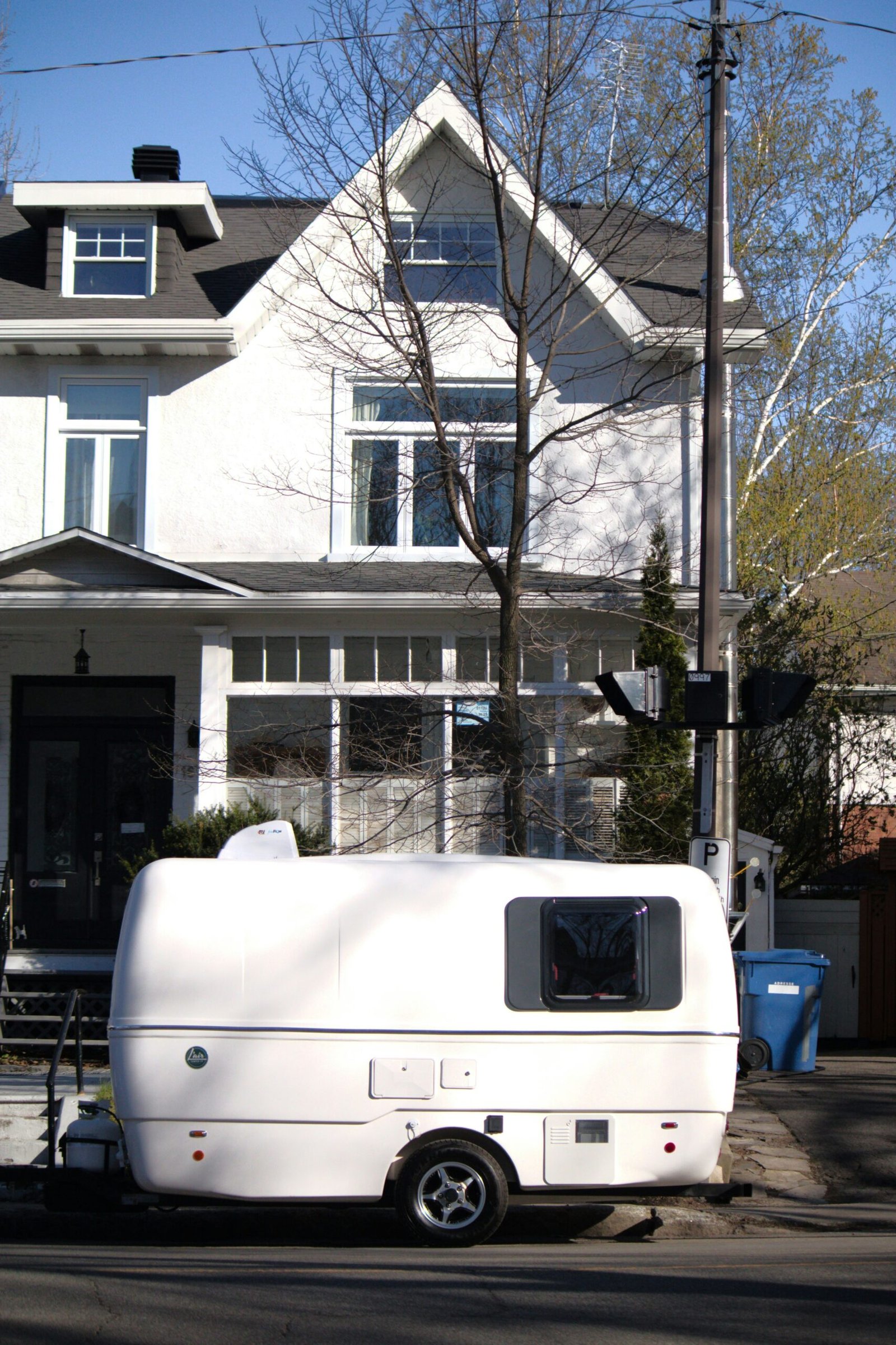 a white trailer parked in front of a white house